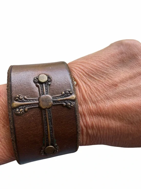 Brown leather cuff bracelet with cross design. Snap closure
