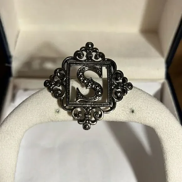 Silver letter S brooch.