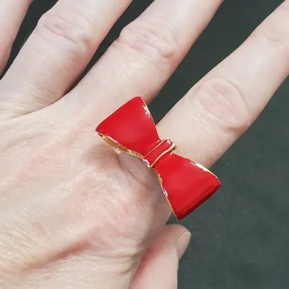 Gold tone red enamel bow ring currently a 7
