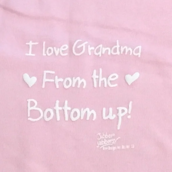 Pink Baby One-Piece Bodysuit w/White Print “I Love Grandma From The Bottom Up!”.