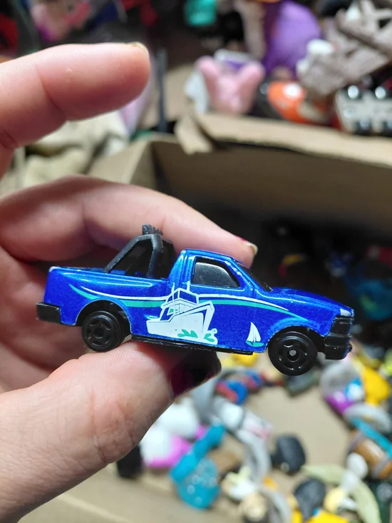 blue diecast pickup truck is a 1:64 scale model, possibly from a 