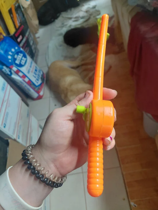 kids toy orange plastic fishing pole with green worm as bait