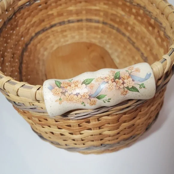 Woven oval basket with porcelain handles with floral design / artist signed 2006
