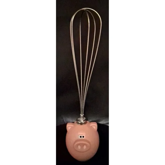 Novelty pig-themed whisk with a pink resin handle. By Jo!e