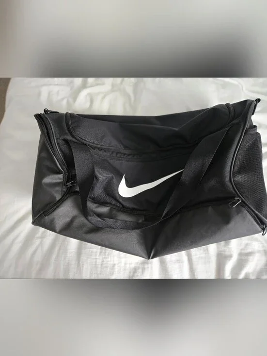 Nike Black Duffel Bag with White Swoosh and Bottom Zipper Pocket.
