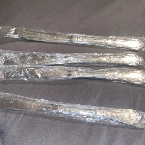 Set of four, new in plastic, stainless steel flatware knives