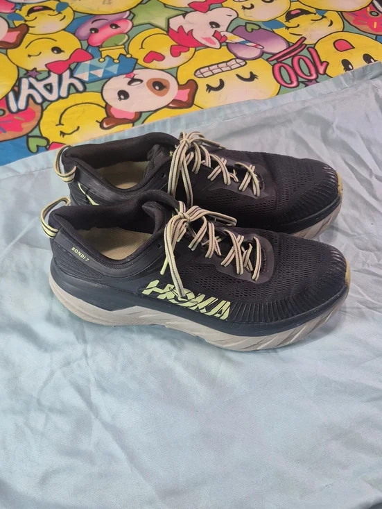 Hoka black running shoes with pale yellow logo