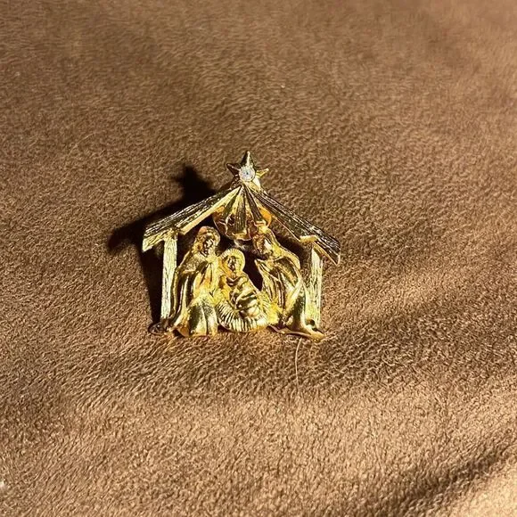 Live nativity gold brooch.