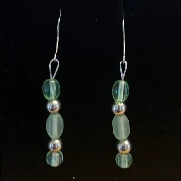 Handcrafted silver tone earrings with green colored beads.