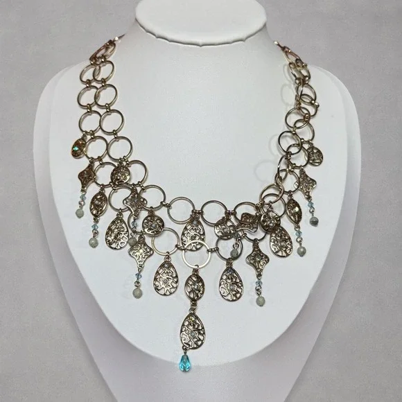Silver tones necklace with intricate filigree and green and blue dangling charms