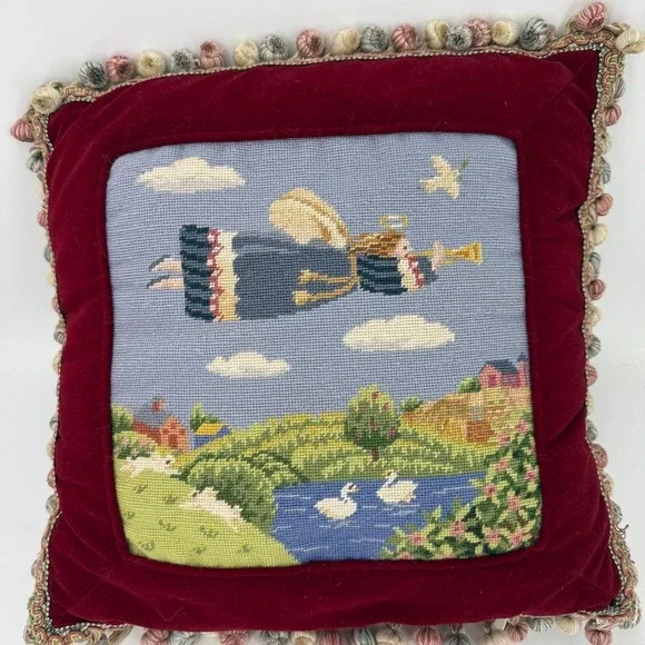 Needlepoint pillow featuring a folk art angel motif dark red velvet background