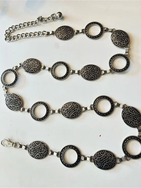 Silver-tone chain belt features textured medallion links and a hook closure L/XL