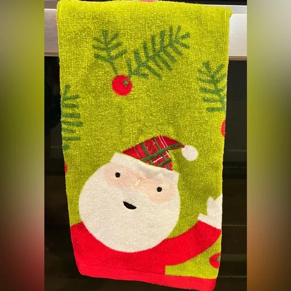 Christmas hand towel a smiling Santa Claus with a pine needle pattern.