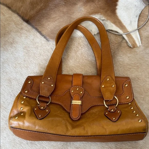 This is a vintage Michael Kors brown leather shoulder bag featuring gold studs