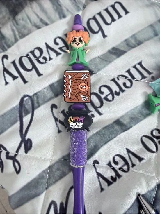Hocus Pocus beaded pen with red haired witch, cauldron and book.