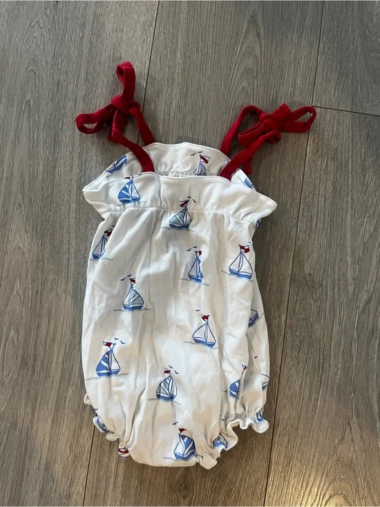 The Beaufort Bonnet Company White Romper with Blue Sailboats and Red Tie Straps
