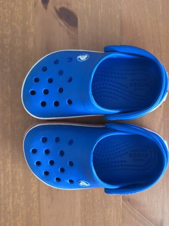 Toddler blue Crocs with red and white band
