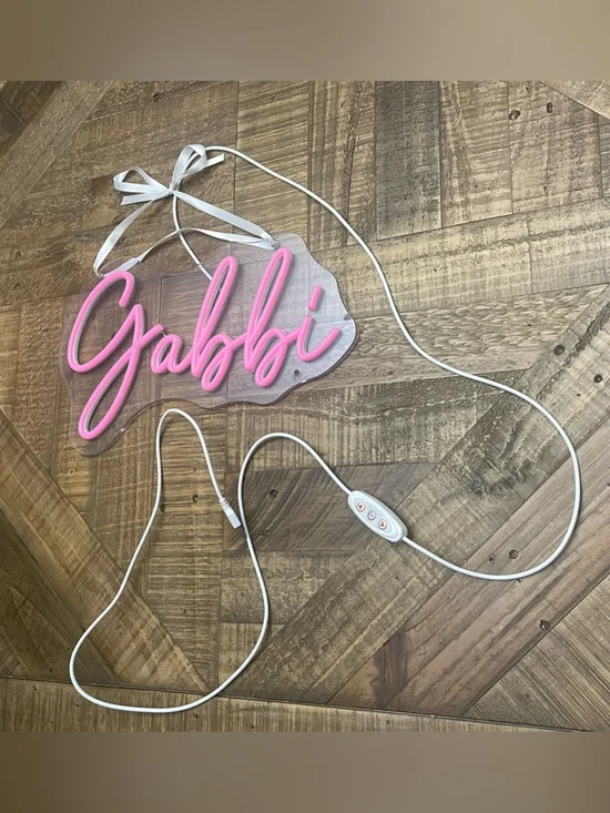 custom Gabbi pink neon-style LED name sign on a clear acrylic backing.