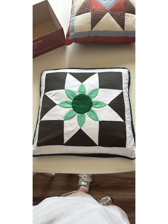 Handmade quilted throw pillow with floral star pattern